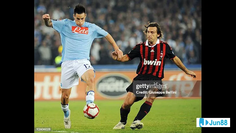 นักเตะ AC Milan เลี้ยงบอลผ่านกองหลังของ Napoli ในการแข่งขัน